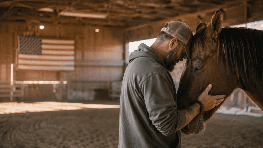 Veteran sharing a quiet moment with a therapy horse inside a rustic barn.